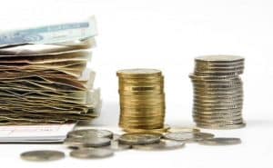 stosy monet i plik banknotów